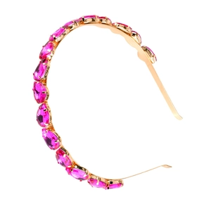 Detail of gold metal headband featuring a neat row of sparkling pink teardrop gemstones