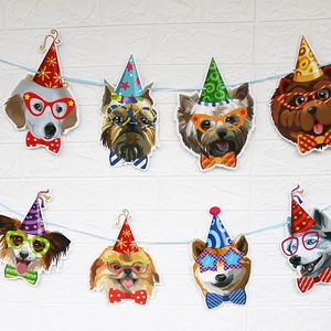 Close-up of dog face banners with birthday hats and bow ties on blue ribbon