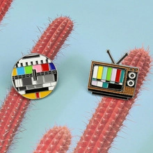 Detailed macro shot of circular and vintage TV enamel pins with SMPTE color test patterns
