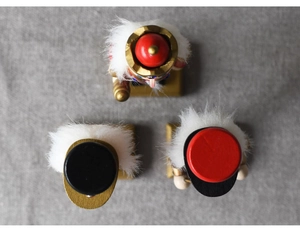 Top view of three wooden nutcracker soldiers with red, black, and gold festive hats