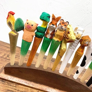 Detailed group view of hand-carved wooden pens featuring various colorful animal designs