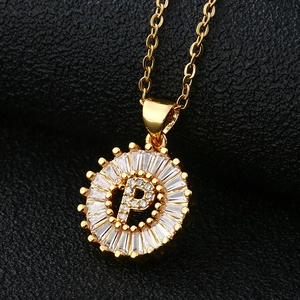 Gros plan du collier doré avec pendentif lettre P serti de zircons sur cuir noir texturé