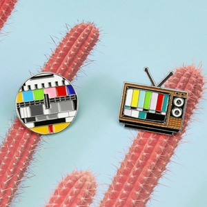 Retro TV color test pattern enamel pin set on a decorative red cactus display