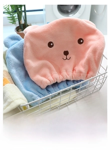 Detail of pink and blue microfiber hair towels with cute bear ears in a storage basket