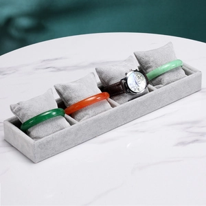 Detail view of grey velvet watch display tray with four soft pillows for bracelet storage