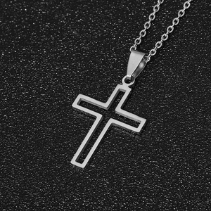 Macro shot of silver hollow cross pendant with polished stainless steel chain