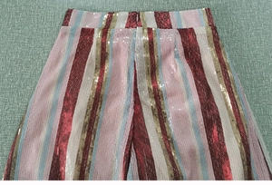 Dettaglio dei pantaloni a righe con paillette colorate e vita alta in stile chic