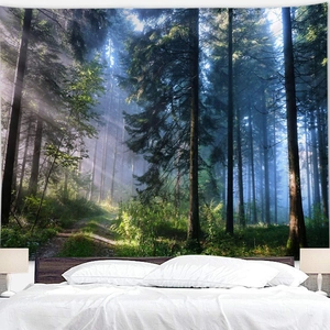 Detail of forest wall tapestry with morning fog over a double bed in home setting