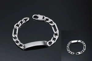Detailed macro view of silver Figaro chain bracelet with a polished engravable metal ID plate