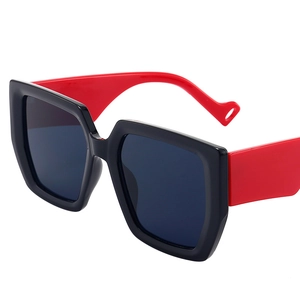 Retro oversized square sunglasses featuring glossy black frames with bold red temples