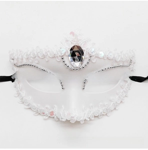 Close-up of white lace masquerade mask with silver beads and sparkling central gemstone