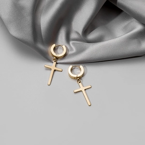 Polished gold stainless steel hoop earrings with cross pendants on silk background