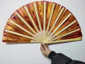 Close-up of a 33cm Kung Fu folding fan with orange laser foil and bamboo ribs