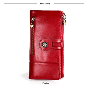 Close-up of red leather wallet featuring rose metal emblem and heart zipper pendant