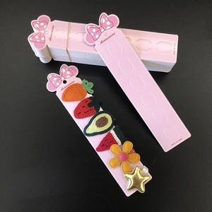 Pink hair clip display card with cute knitted carrot, strawberry, and flower accessories