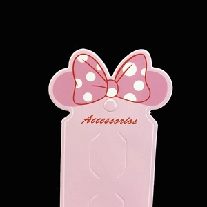 Pink hair accessory display card with polka dot bow and Accessorios text
