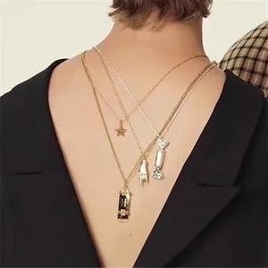 Layered gold and silver streetwear necklace set with star and candy pendants on model