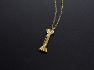 Macro shot of a golden candy-shaped pendant on a delicate titanium steel chain