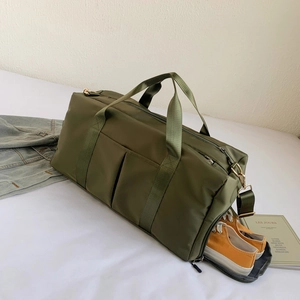 Detail of olive green gym bag featuring a dedicated side shoe compartment and soft texture