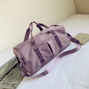 Detail view of purple waterproof travel bag with side pockets and adjustable shoulder strap
