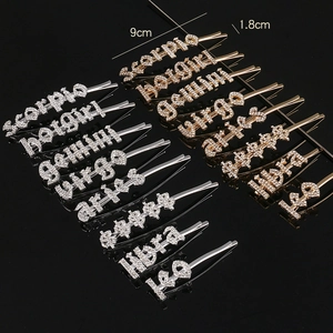Macro detail of gold and silver zodiac rhinestone hair clips in various letter designs
