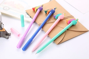 Close-up of four colorful cartoon peacock pens on a desk with a kraft envelope