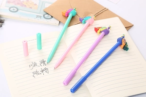 Detail of four colorful peacock cartoon pens on a notebook showing fine silicone toppers