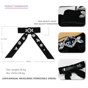 Detail of black velvet bow hair clip showing blue crystal rhinestones and metal spring clip