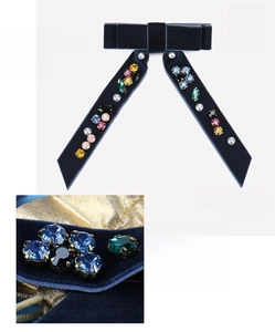 Detail of blue velvet bow hair clip featuring colorful rhinestones and faux pearls