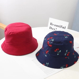 Detail of kids reversible bucket hat in red and navy blue cherry print with reinforced stitching