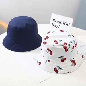 Detail of reversible kids bucket hats in navy twill and white cherry print fabric