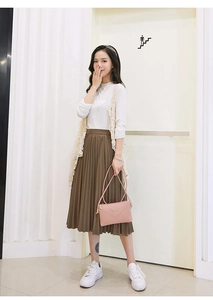 Fashionable autumn outfit featuring a pink mini crossbody bag with lace vest and brown skirt