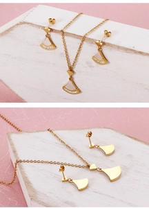 Détail d'un ensemble collier et boucles d'oreilles dorés en forme d'éventail avec nacre