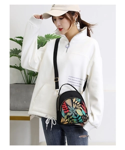 Detailed shot of waterproof black Oxford bag with colorful embroidered leaf patterns
