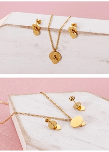 Close-up of gold heart and ring jewelry set with LOVE and Roman numeral engraving