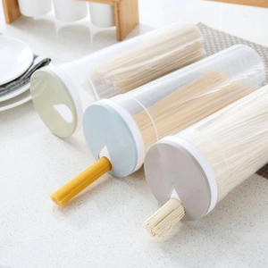 Three plastic noodle storage jars with rotating measuring lids in a kitchen setting