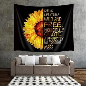 Close-up of black tapestry with sunflower and inspirational quote on a rustic wall