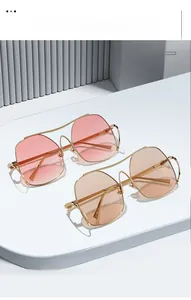 Detail of gradient lenses and golden double-bridge metal frames on polygonal sunglasses