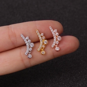 Three flower zircon ear studs in silver, gold, and rose gold finishes on a finger