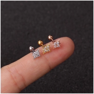 Mini stainless steel flower tragus studs in silver, gold and rose gold on a fingertip