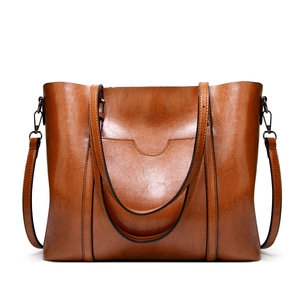 Sac cabas rétro en cuir ciré marron avec double bandoulière sur fond blanc uni