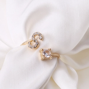 Detailed shot of an adjustable gold ring with letter S and a sparkling zircon stone
