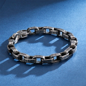 Retro engraved skull chain bracelet for men made of stainless steel on blue background