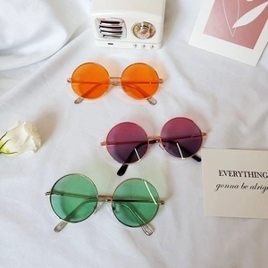 Classic round metal kids sunglasses in orange, magenta, and green on white background