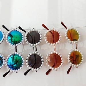 Kids' round sunglasses with pearl frames available in green, black, tea, and orange lenses