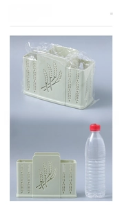 Size comparison of green wall-mounted kitchen utensil holder with a mineral water bottle