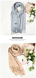 Detailed view of thick cashmere-like scarves in grey and khaki with fringe edges
