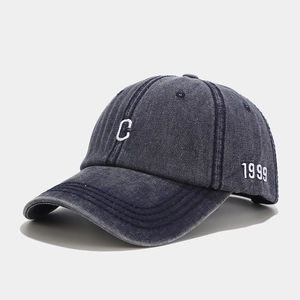Close-up of vintage washed denim baseball cap with white C embroidery and 1999 side detail