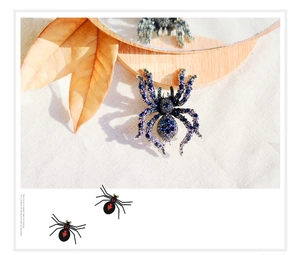 Close-up of vintage silver spider brooch with deep blue rhinestones and crystal detail