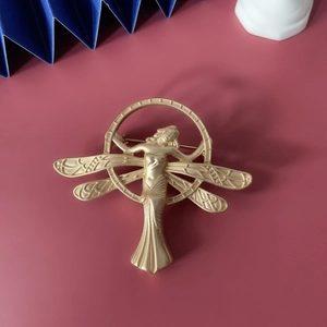 Vintage matte gold winged angel brooch in artistic circular baroque frame design